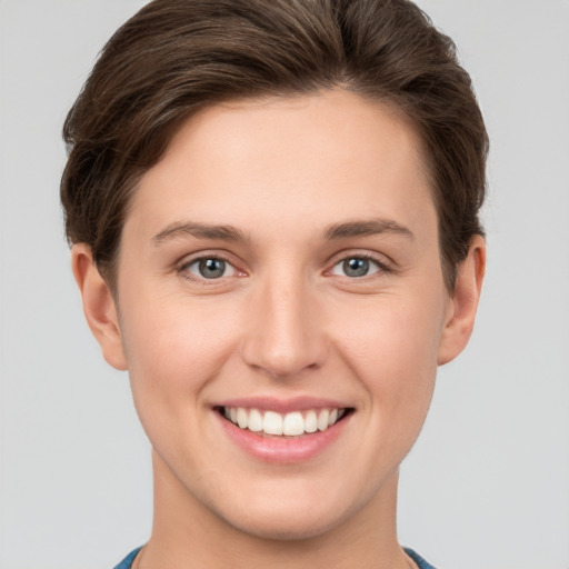 Joyful white young-adult female with short  brown hair and grey eyes