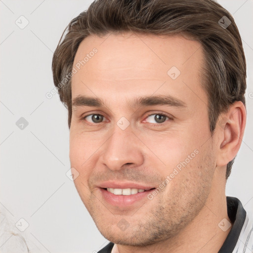 Joyful white young-adult male with short  brown hair and grey eyes