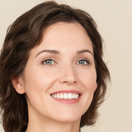 Joyful white young-adult female with medium  brown hair and green eyes