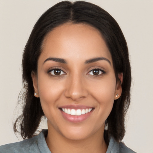 Joyful latino young-adult female with medium  black hair and brown eyes