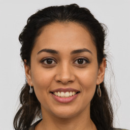 Joyful latino young-adult female with long  brown hair and brown eyes