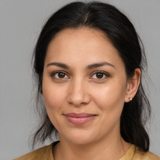 Joyful latino young-adult female with medium  brown hair and brown eyes