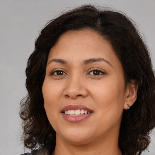 Joyful latino young-adult female with medium  brown hair and brown eyes