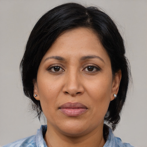 Joyful latino adult female with medium  brown hair and brown eyes