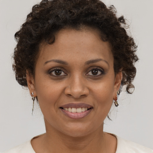 Joyful black young-adult female with short  brown hair and brown eyes