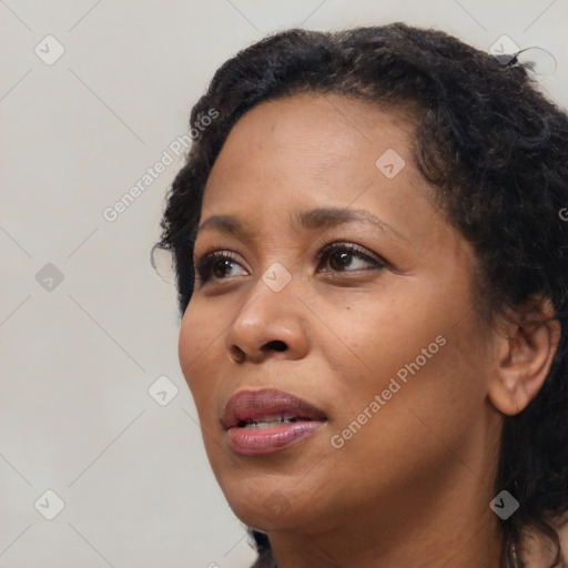 Joyful black adult female with long  brown hair and brown eyes