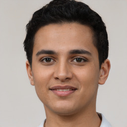 Joyful latino young-adult male with short  black hair and brown eyes