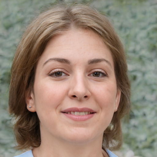 Joyful white young-adult female with medium  brown hair and green eyes