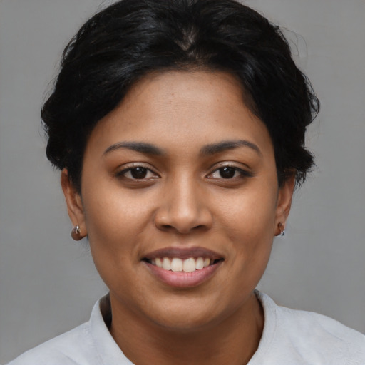 Joyful latino young-adult female with short  black hair and brown eyes