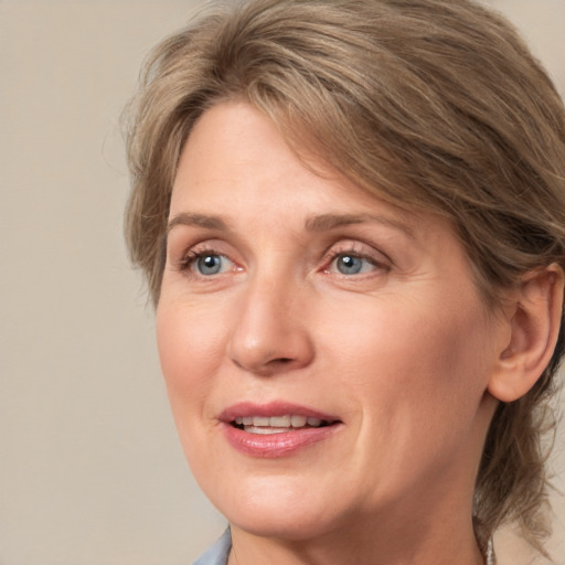 Joyful white adult female with medium  brown hair and blue eyes