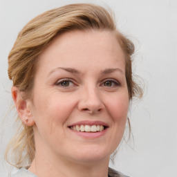 Joyful white young-adult female with medium  brown hair and blue eyes