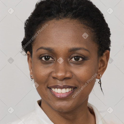 Joyful black young-adult female with short  black hair and brown eyes