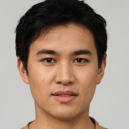 Joyful asian young-adult male with short  black hair and brown eyes