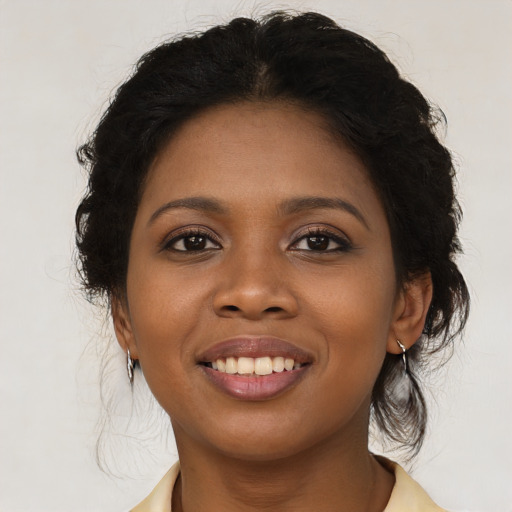 Joyful black young-adult female with long  black hair and brown eyes