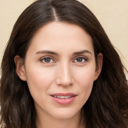 Joyful white young-adult female with long  brown hair and brown eyes