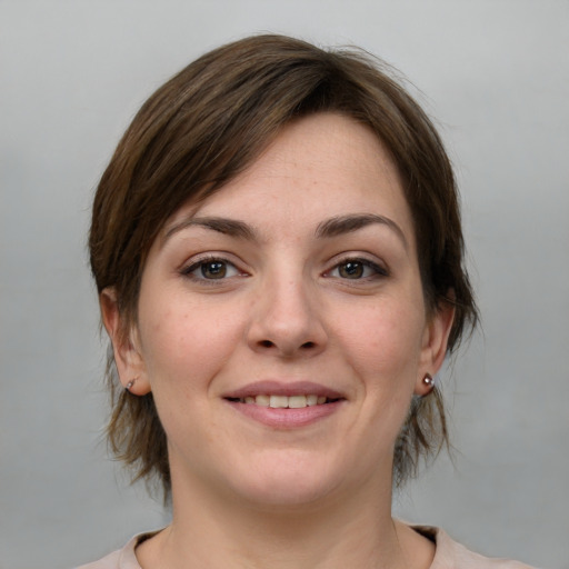 Joyful white young-adult female with medium  brown hair and grey eyes