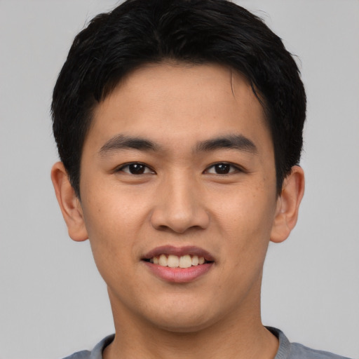 Joyful asian young-adult male with short  black hair and brown eyes