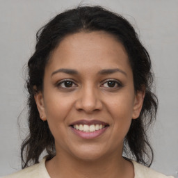 Joyful latino young-adult female with medium  brown hair and brown eyes