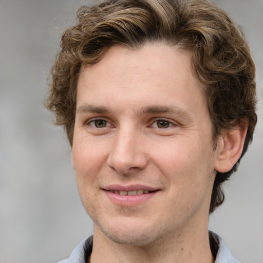 Joyful white adult male with short  brown hair and grey eyes