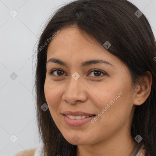 Joyful latino young-adult female with long  brown hair and brown eyes