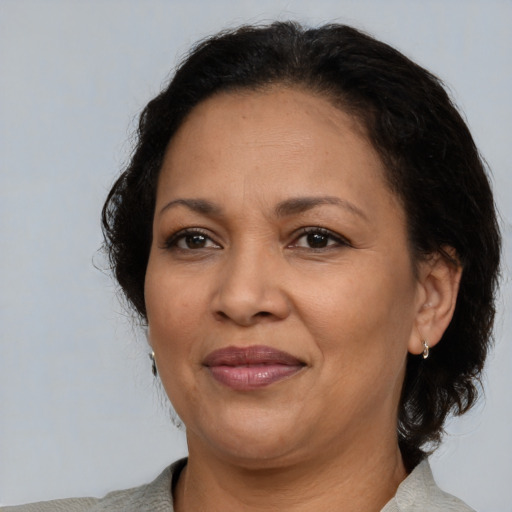 Joyful latino adult female with medium  brown hair and brown eyes