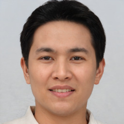 Joyful asian young-adult male with short  black hair and brown eyes