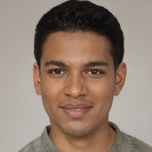 Joyful black young-adult male with short  black hair and brown eyes