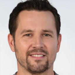 Joyful white adult male with short  brown hair and brown eyes