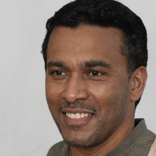 Joyful latino adult male with short  black hair and brown eyes