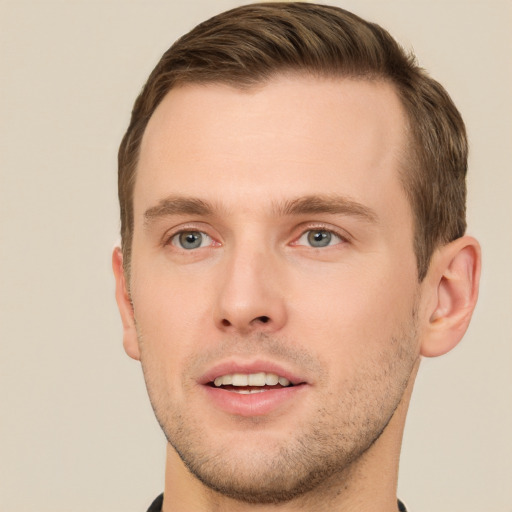 Joyful white young-adult male with short  brown hair and grey eyes