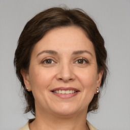 Joyful white adult female with medium  brown hair and grey eyes