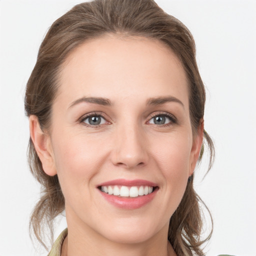 Joyful white young-adult female with medium  brown hair and grey eyes