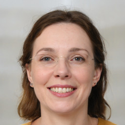 Joyful white young-adult female with medium  brown hair and blue eyes