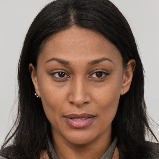 Joyful latino adult female with long  brown hair and brown eyes