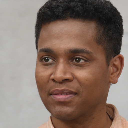 Joyful latino young-adult male with short  brown hair and brown eyes