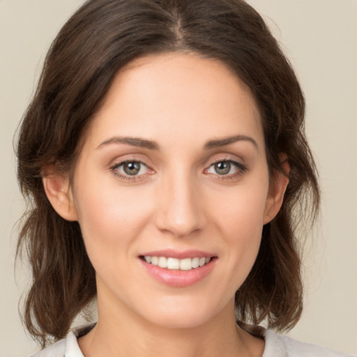 Joyful white young-adult female with medium  brown hair and green eyes