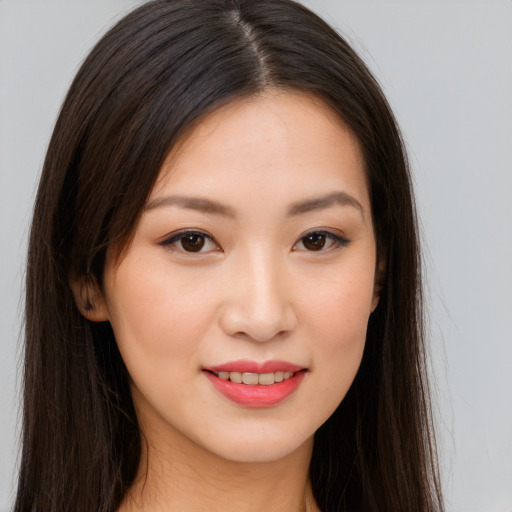 Joyful asian young-adult female with long  brown hair and brown eyes