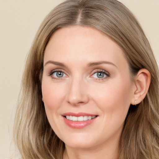 Joyful white young-adult female with long  brown hair and blue eyes