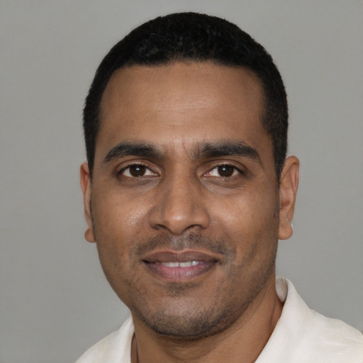 Joyful black young-adult male with short  black hair and brown eyes