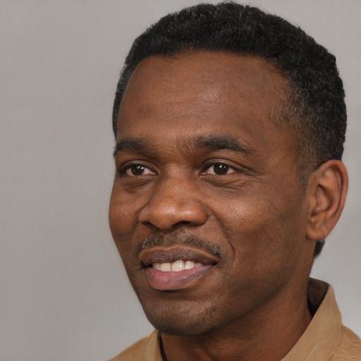 Joyful black adult male with short  black hair and brown eyes