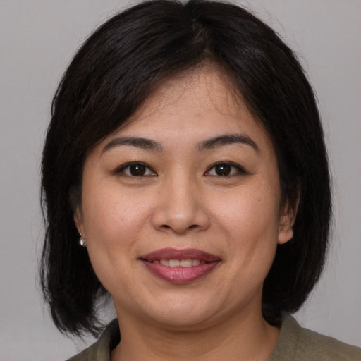 Joyful asian adult female with medium  brown hair and brown eyes
