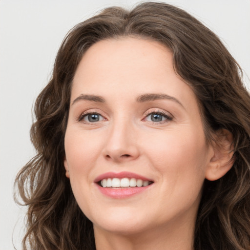 Joyful white young-adult female with long  brown hair and green eyes