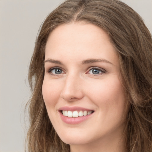 Joyful white young-adult female with long  brown hair and green eyes