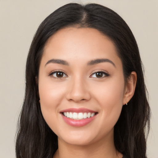 Joyful latino young-adult female with long  brown hair and brown eyes