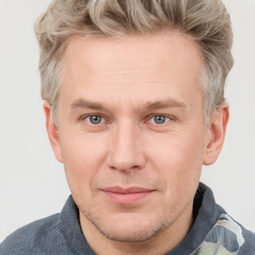 Joyful white adult male with short  brown hair and blue eyes