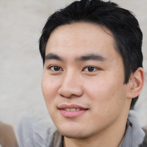 Joyful asian young-adult male with short  black hair and brown eyes