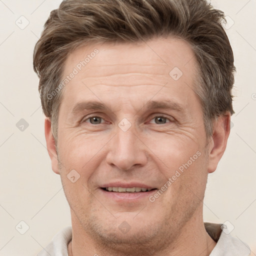 Joyful white adult male with short  brown hair and grey eyes