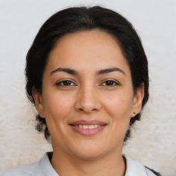 Joyful latino young-adult female with medium  brown hair and brown eyes