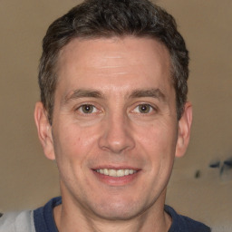 Joyful white adult male with short  brown hair and brown eyes