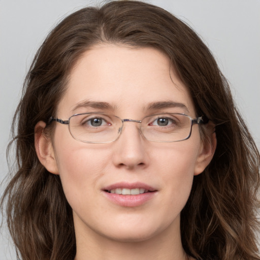 Joyful white adult female with long  brown hair and grey eyes